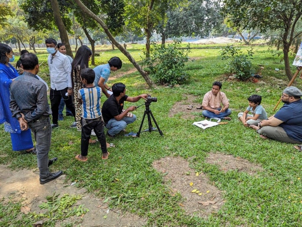 পার্কের সবুজ ঘাসে বধির পথশিশু মিতুল ও চিত্রশিল্পী রেজওয়ান সাহেবের বন্ধুত্বের দৃশ্যধারণ