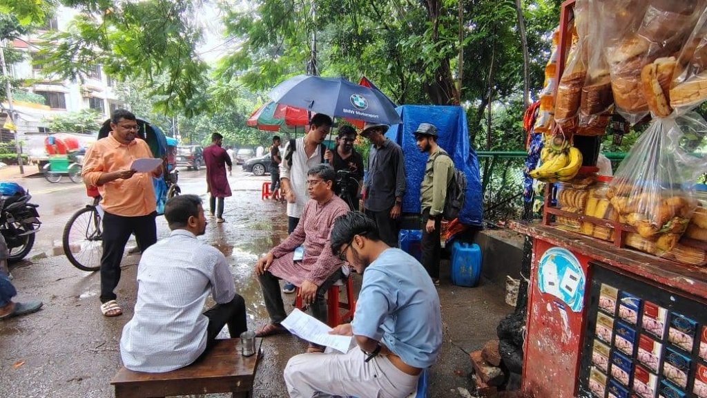 বৃষ্টির আবহে পথপার্শ্বের দোকানে অভিনেতাদের দৃশ্য মহড়া ও শট গ্রহণ