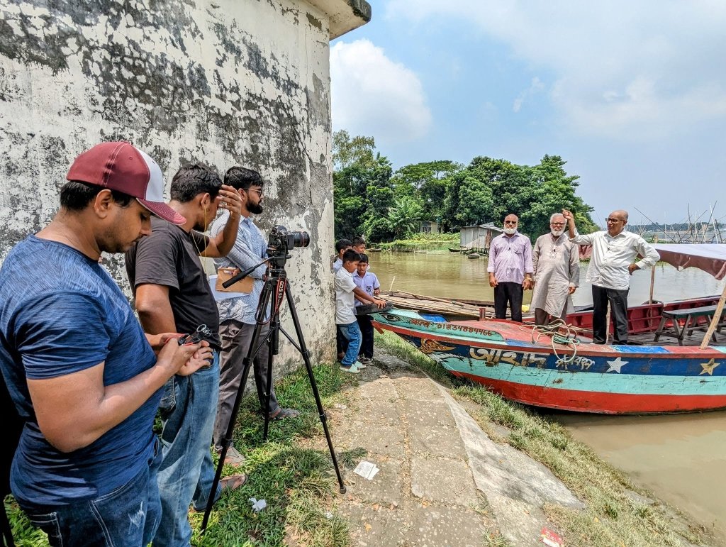 চাঁদপুর নদীতীরে নৌকার ওপর দাঁড়িয়ে ১৯৭১-এর ঐতিহাসিক নৌ-কমান্ডো অপারেশনের লোকেশন ও স্মৃতি বর্ণনা করছেন তিন বীর মুক্তিযোদ্ধা